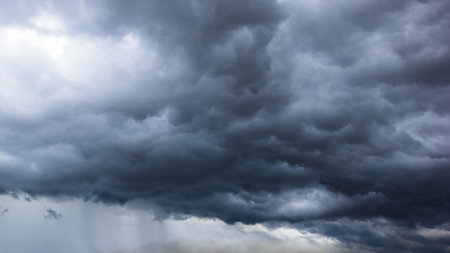 The dark sky with heavy clouds converging and a violent storm before the rain.