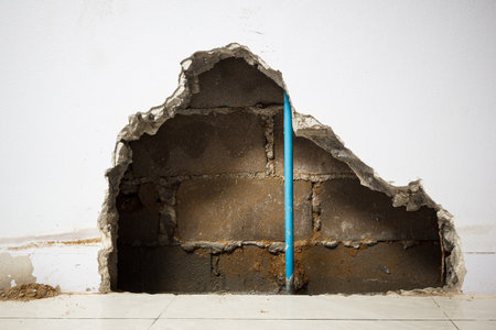 Concrete walls in the shade that have been smashed or destroyed to find holes for water leaks. Home repair concept.の写真素材