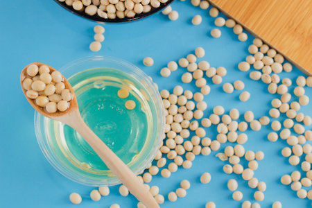 soybean and oil in a bowl on blue background, selective focus.copy space.front view.の写真素材