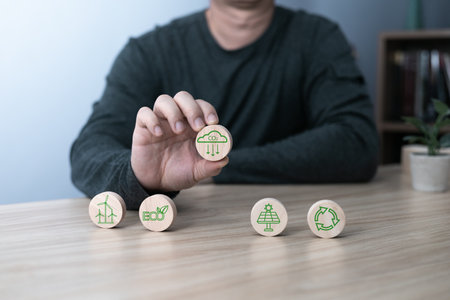 Hand of a businessman chooses reduce co2 icon on wood block circle.idea for environmentally conscious business, climate change, eco-friendly investment,ESG for Environment Social and Governanceの写真素材