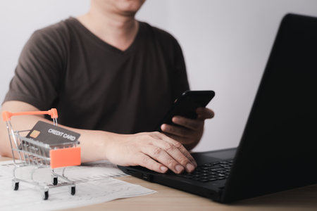 Men use laptop computers and smartphone for business commerce, which is payment online, sits on the...