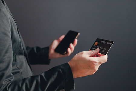 businessman showing a mock-up credit card for business and shopping to make payment and smartphone.half body. purchase, commerce, financial, card, money, using technology. selective focus.の写真素材