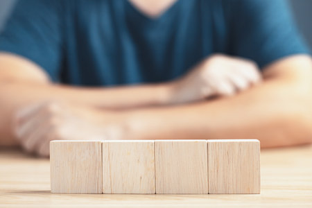 businessman sit on table and  wood empty four blocks with copy space for text or symbols, development concept for growth success process.の写真素材