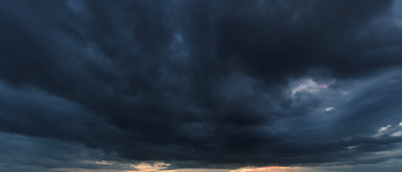 The dark sky with heavy clouds converging and a violent storm before the rain. Bad or moody weather...
