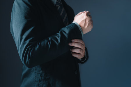 Portrait of businessman in suit standing thoughtful, half body and not showing faceの写真素材
