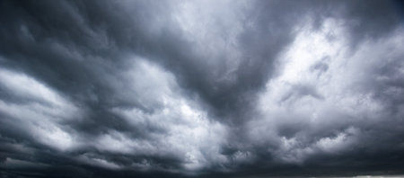 Moody weather sky and environment. climate change. carbon dioxide emissions, greenhouse effect, global warming. The dark sky with heavy clouds converging and a violent storm before the rain.の写真素材