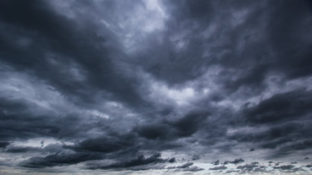 The dark sky with heavy clouds converging and a violent storm before the rain. Bad or moody weather sky and environment.の写真素材