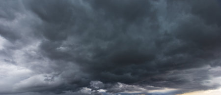 The dark sky with heavy clouds converging and a violent storm before the rain. Bad or night weather sky and environment.の写真素材
