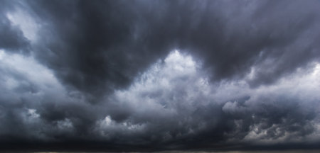 The dark sky with heavy clouds converging and a violent storm before the rain. Bad or moody weather...