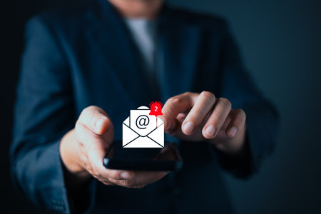 businessman in suit interacts with a digital email notification icon hovering above his smartphone....