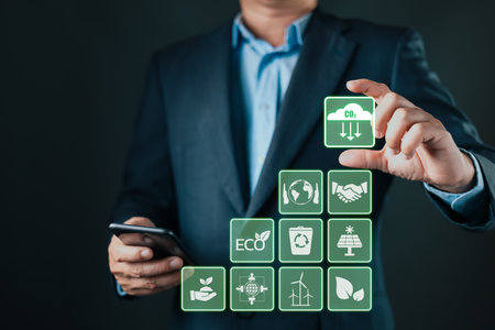 A businessman interacts with eco-friendly digital icons representing sustainability, renewable energy, recycling, and CO2 reduction, symbolizing green innovation and environmental responsibility.の写真素材