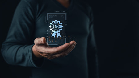 A person holds a glowing holographic certificate featuring an ISO badge, symbolizing international standards, quality assurance, compliance, and certification in modern digital business practices.の写真素材