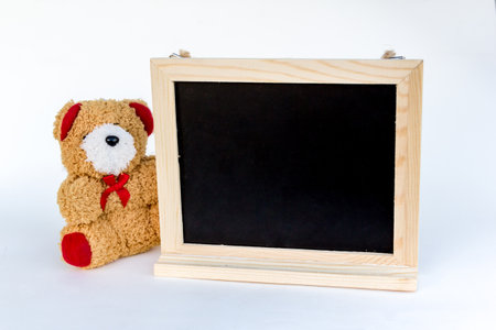 bear doll and blank wood frame on white backgroundの写真素材