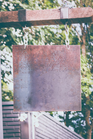 blank rusty metal hanging on wood bar for shop, vintage toneの写真素材