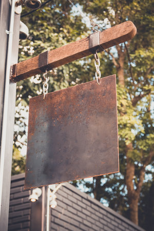 blank rusty metal hanging on wood bar for shop, vintage toneの写真素材