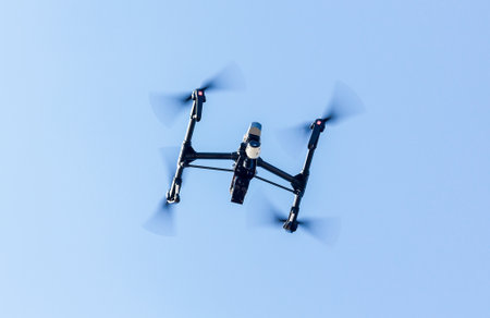 black drone quadcopter with digital camera with blue sky