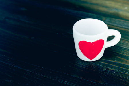 coffee cup with red heart on wooden table, film toneの写真素材