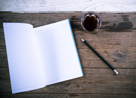 notebook coffee and pencil on wood table, top viewの写真素材