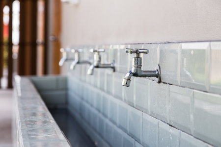 row of faucet and long sink at the toiletの写真素材