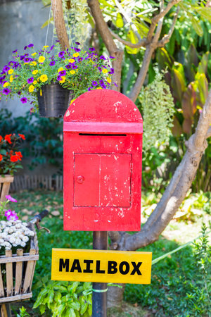 the old red wooden mailbox in the gardenの写真素材