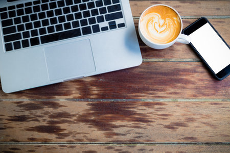 office stuff with laptop coffee cup and smart phone, top viewの写真素材