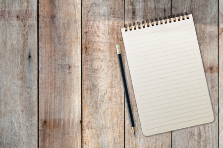 blank notepad and pencil on wood backgroundの写真素材