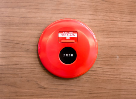 red fire alarm on wood wall