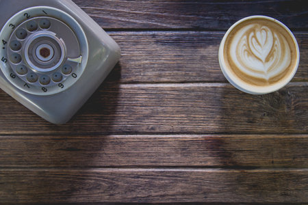 coffee on wood table with old telephone, top viewの写真素材