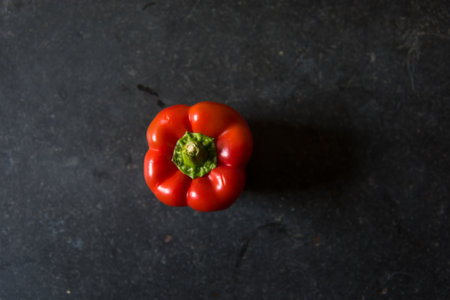 View from above of red bell pepper on a black background with use of selective focus.の写真素材