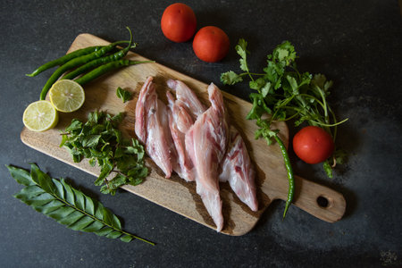 Top view of raw fish fillet meat with vegetables on a wooden boardの写真素材