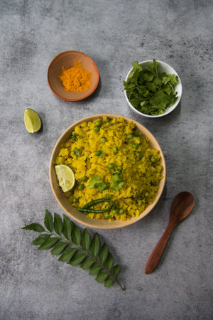 Coriander leaves and turmeric powder as condiments along with a bowl of poha with use of selective...