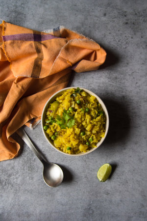 Top view of poha or cooked flattened rice in a bowl on a background