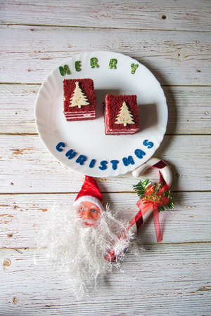 Delicious red velvet cake along with Christmas decorations of Santa Claus and ribbonの写真素材