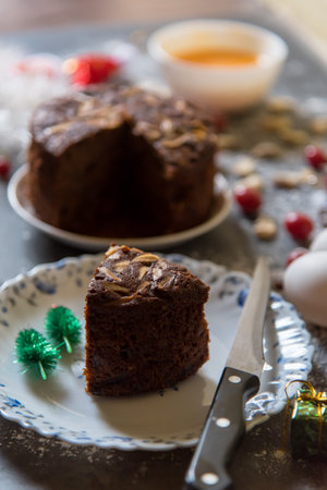 Close up of a chocolate cake slice with nuts and raisins with use of selective focus.