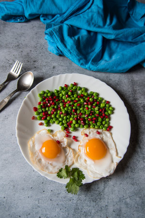 Poached eggs and freshly steamed vegetables in a plate. Top view, selective focus.の写真素材