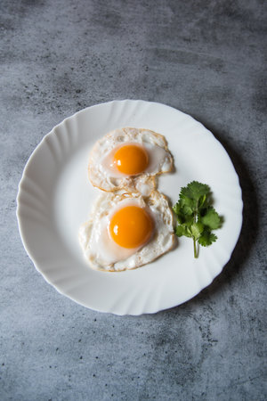 Egg poach sunny side up a healthy food ingredient on a plate. View from top, selective focus.
