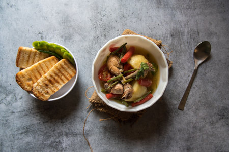 Healthy food chicken stew prepared along with vegetables in a bowl and bread slices