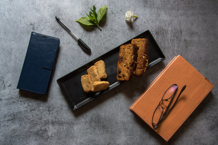 Top view of sliced cake and biscuits on a black tray. Selective focus.の写真素材