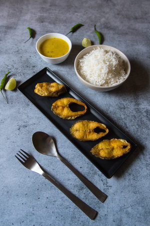 Bengali style lunch menu fried fish served with steamed rice and pulses. Top view, selective focus.の写真素材