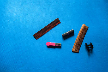 Grooming accessory items nail clipper, comb, hair clip and lipstick on a background with use of...