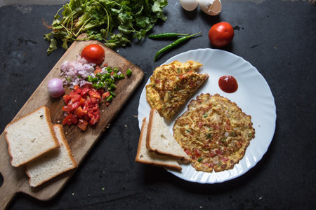 Popular Indian cuisine masala omelette served with bread slices.
