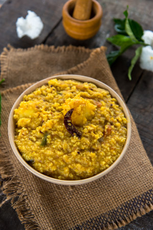 Khichdi or Khichadi, a popular Indian recipe. The food is made of dal or lentils and rice combined with Indian spices and tomatoes. Close up. Selective focus.の写真素材