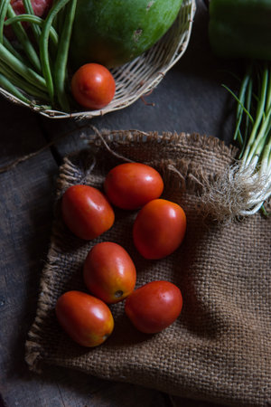 Red tomato on jute sack background. Close up, selective focus.の写真素材