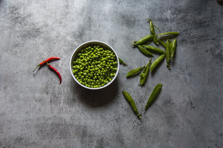 Top view of green peas in a white bowl on a background.の写真素材