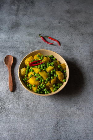 Indian food menu alu matar or fried peas potato in a bowl.の写真素材