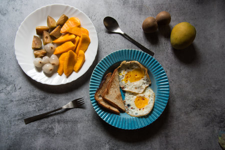 Bread slices and egg poach in a blue bowl. Top view, selective focus.の写真素材