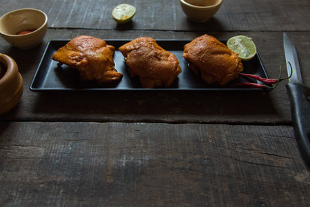 Chicken breast marinated in Indian spices on a black tray. Close up.の写真素材