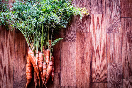 Carrots with leaves on wooden background