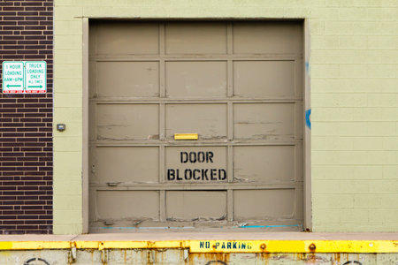 Garage door at an old warehouse loading dock with no parking sign in front の写真素材