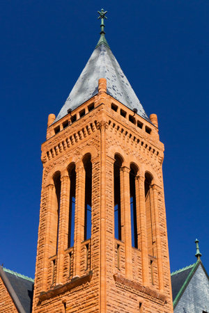 Cross on a church steeple isolated against a blue sky backgroundの写真素材